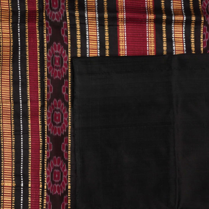 Detailed view of hand-woven silk fabric texture and butta patterns on a red Sambalpuri saree.