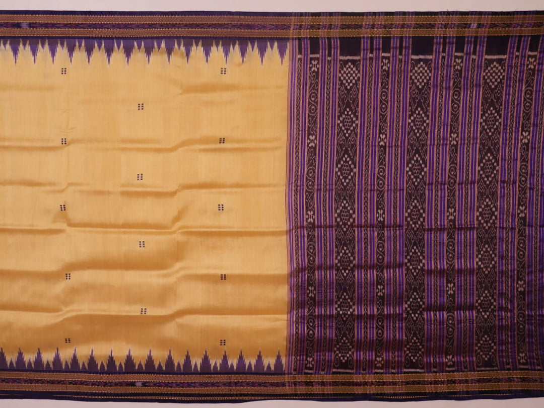 Woman draped in a cream and blue Khandua silk saree with butta pattern, showcasing the elegant drape and styling.