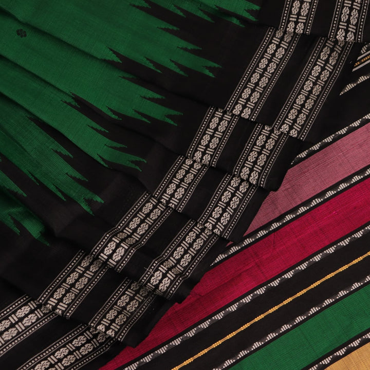 A close-up view of the lush, green silk fabric with a black butta pattern woven in.