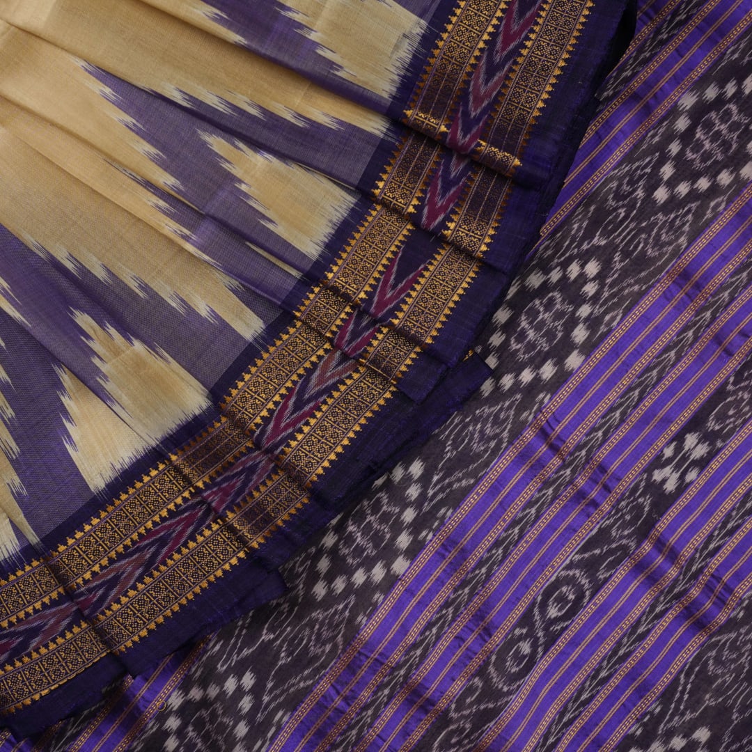 Model draped in a cream and blue Khandua silk saree with butta patterns, showcasing traditional styling.