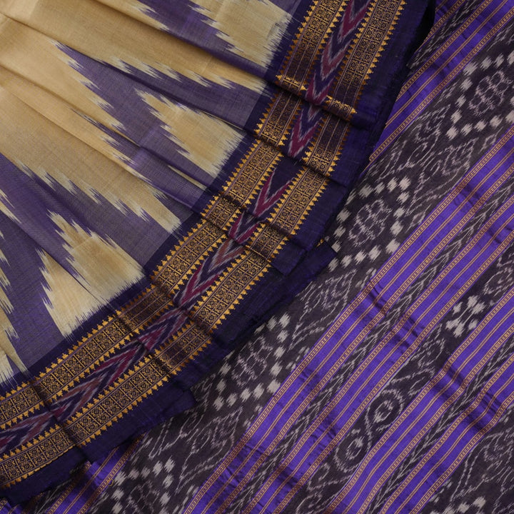 Model draped in a cream and blue Khandua silk saree with butta patterns, showcasing traditional styling.