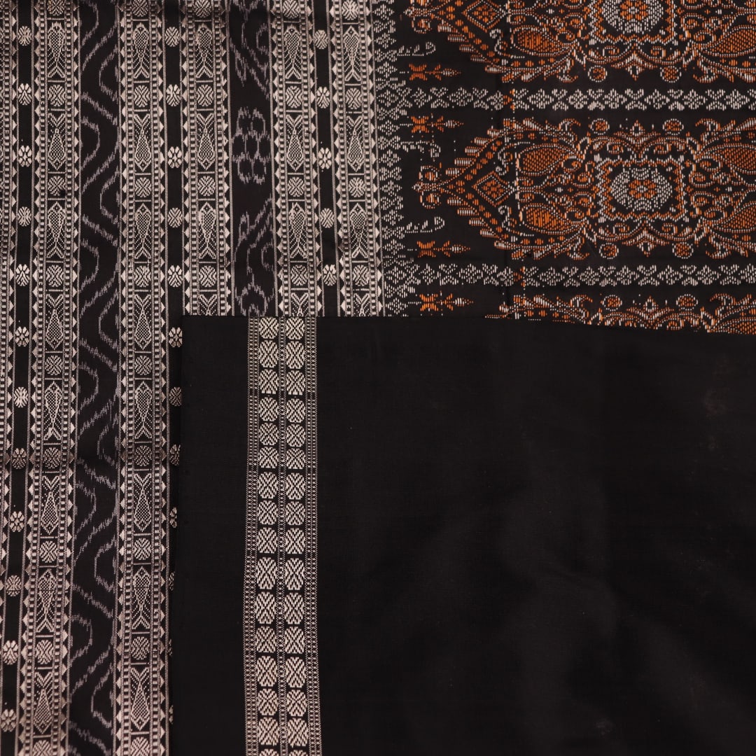 Close-up of magenta and black Bomkai silk saree texture, showing butta pattern weave.