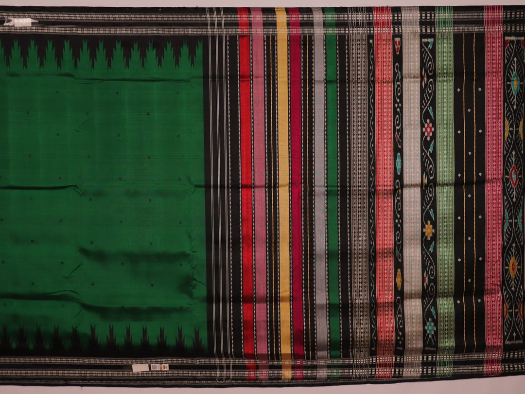 A close-up view of the lush, green silk fabric with a black butta pattern woven in.