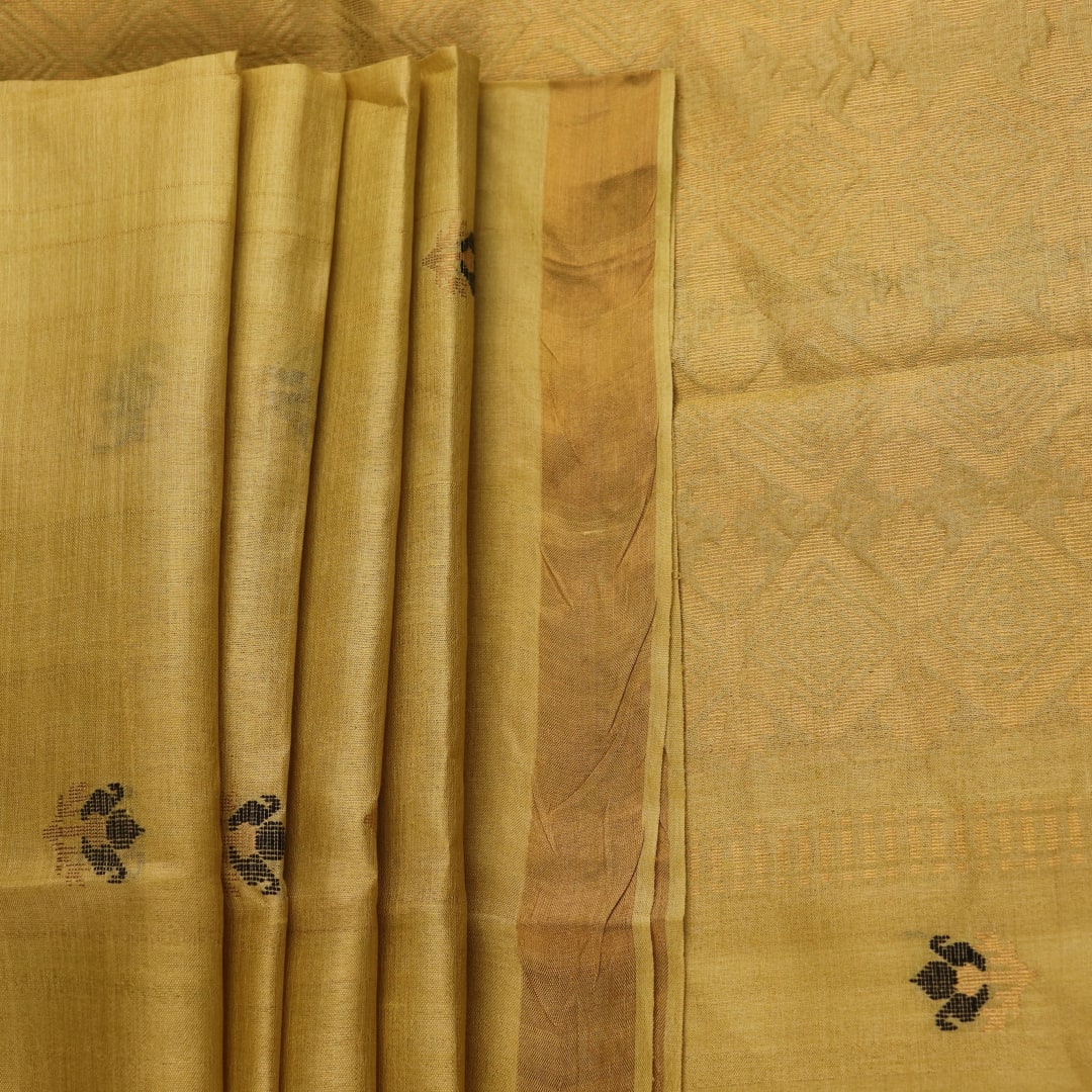 Close-up of yellow Tussar silk saree fabric with intricate butta patterns