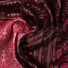Close-up of peach and maroon Sambalpuri silk saree fabric showing intricate handloom texture and motifs.