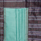 Ultra close-up of the luxurious green Sambalpuri handloom silk weave, highlighting its smooth texture.
