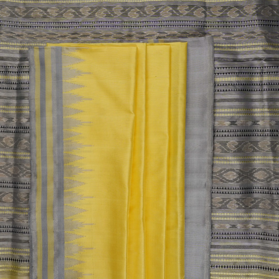 Close-up of the luxurious yellow Sambalpuri silk fabric, showing its fine weave and texture.