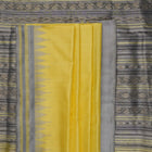 Close-up of the luxurious yellow Sambalpuri silk fabric, showing its fine weave and texture.