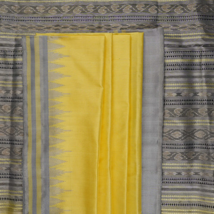 Close-up of the luxurious yellow Sambalpuri silk fabric, showing its fine weave and texture.