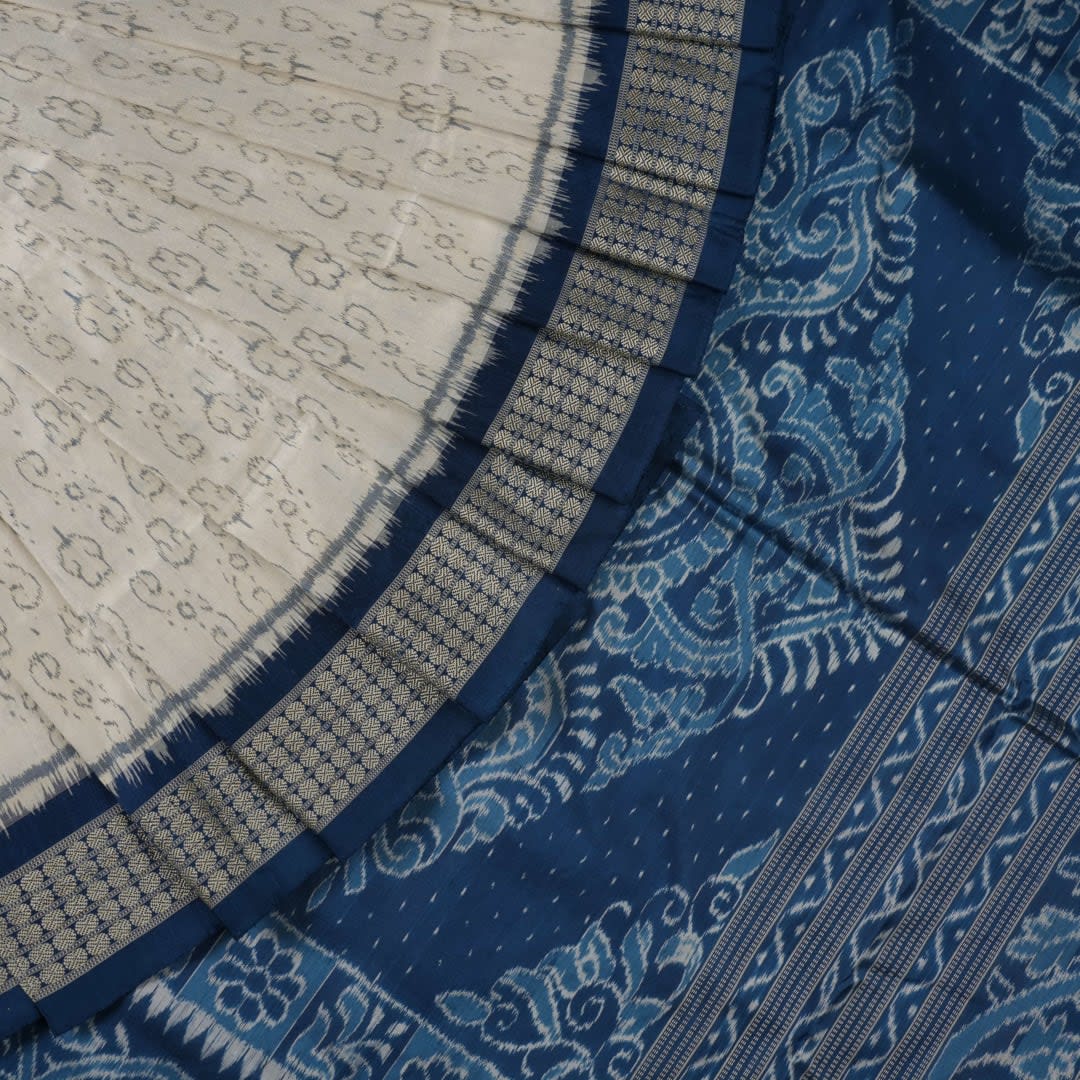 Close-up of premium fabric texture and handloom weave on a white and blue Sambalpuri silk saree