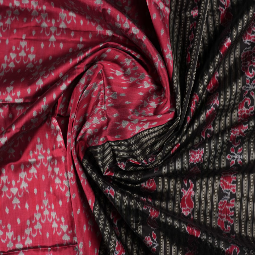 Detailed close-up of the maroon and black Sambalpuri silk saree's luxurious fabric texture and weave.