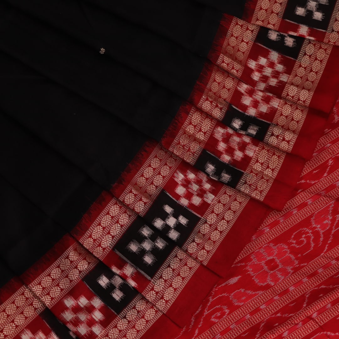 Close-up of black and red silk saree fabric with intricate Sambalpuri motifs