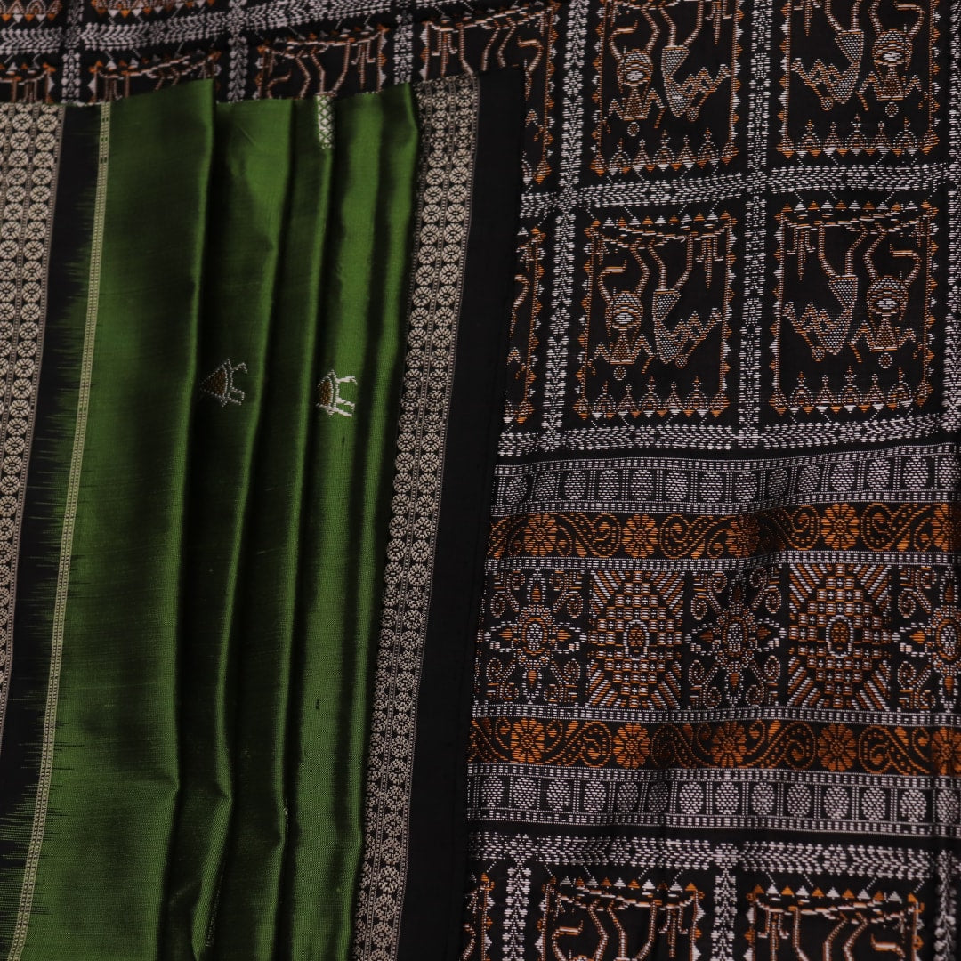 Close-up view of the silken texture of the Sambalpuri silk saree, showcasing green and black woven motifs.