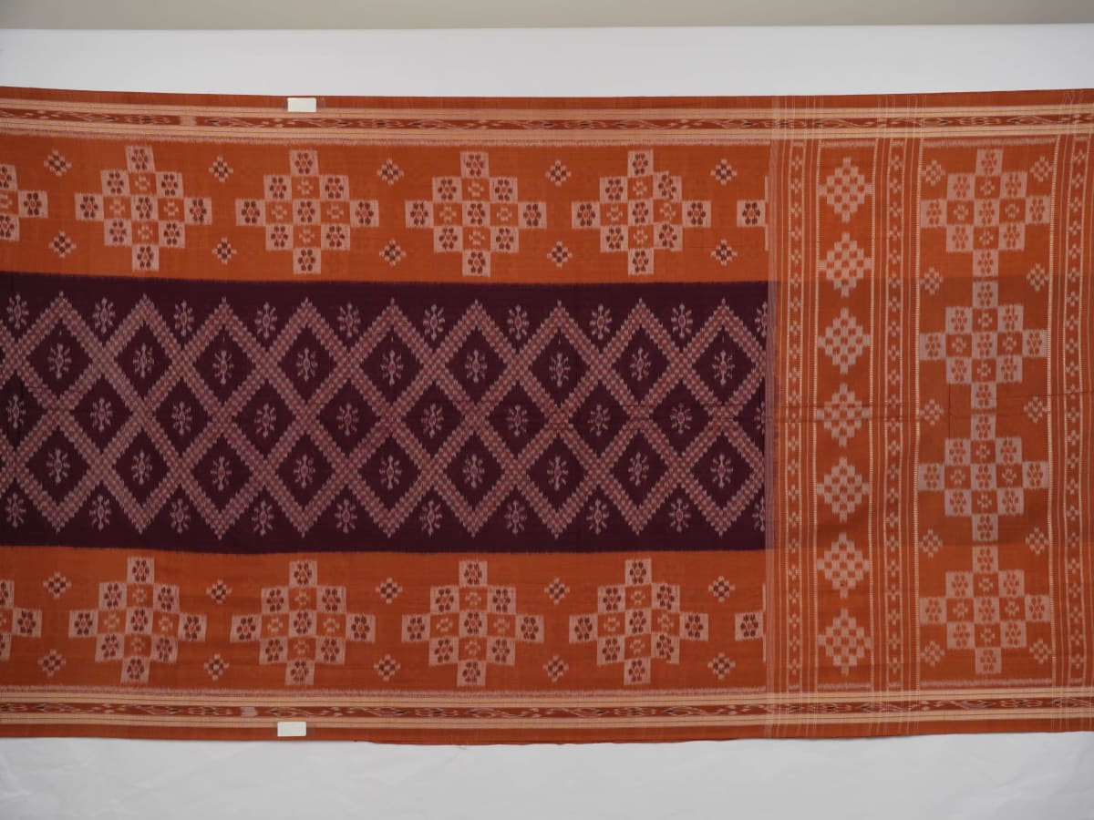 Model draped in a maroon and brown Sambalpuri cotton saree showcasing traditional Odisha handloom style.