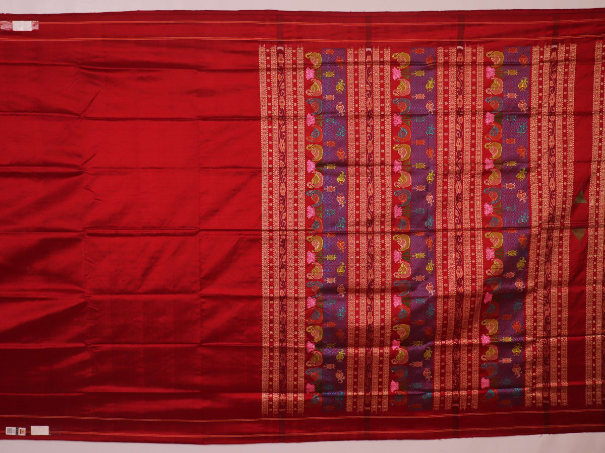 Close-up of maroon plain Sambalpuri silk saree fabric texture.