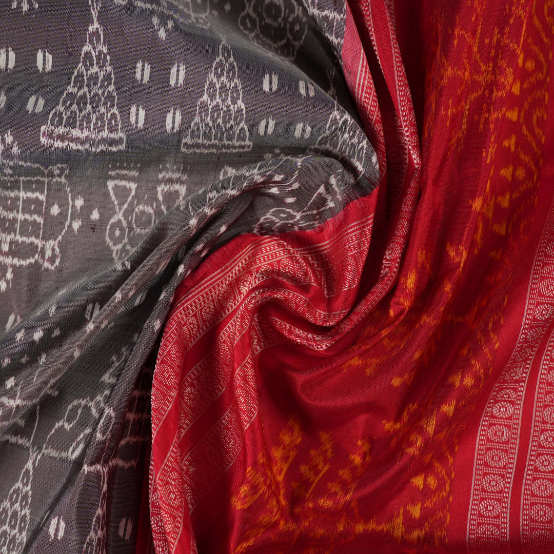 Close-up of the soft, lustrous grey Sambalpuri silk fabric texture, highlighting the intricate weave and motifs.