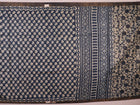 Close-up of blue printed Tussar silk saree fabric texture.