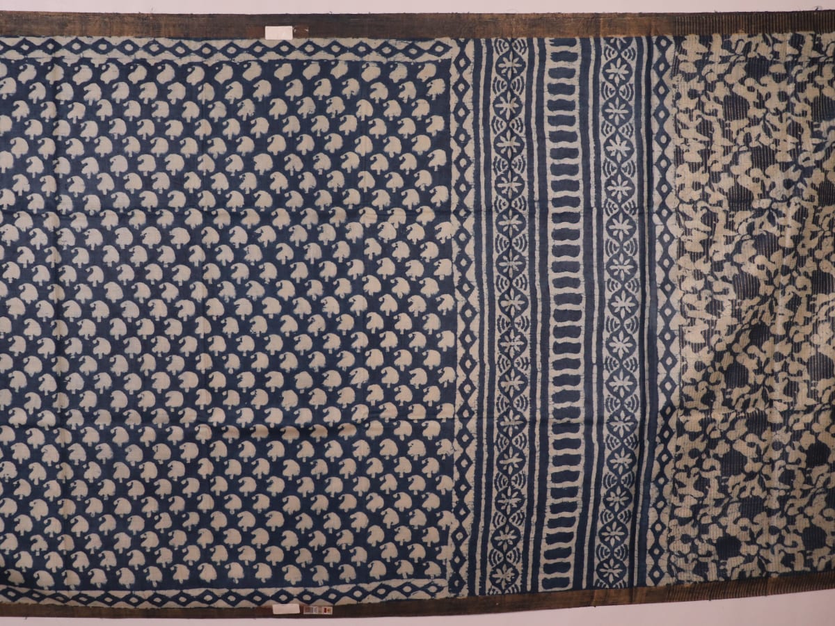 Close-up of blue printed Tussar silk saree fabric texture.