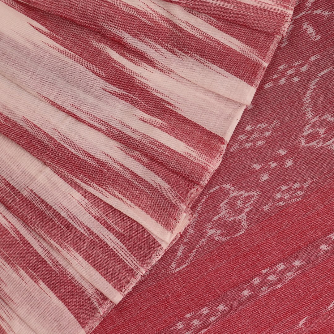 Model wearing a white and maroon Sambalpuri cotton saree with motifs, demonstrating a stylish drape.
