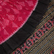 Close-up of the luxurious, handloom silk texture of the red Sambalpuri saree, showing the weave.