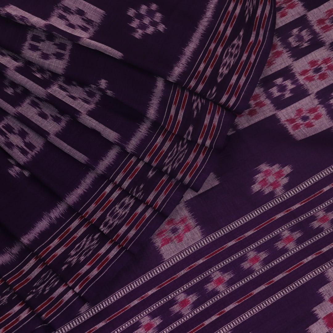 Elegantly draped red and violet Sambalpuri cotton saree with traditional motifs.