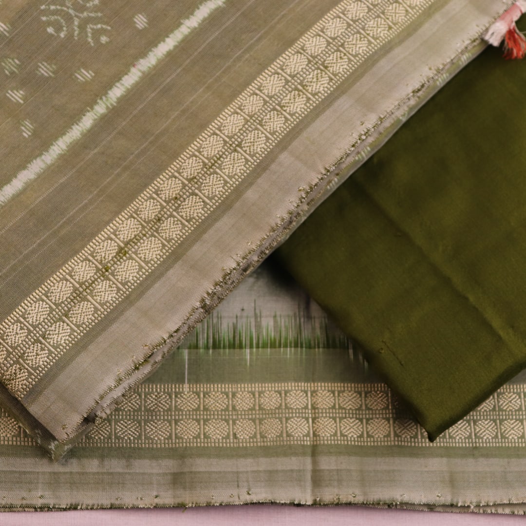 Detail of green Bomkai silk dress material's blouse piece with intricate motifs.