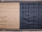 Close-up detail of the cream-colored silk fabric texture with blue motifs in Sambalpuri saree