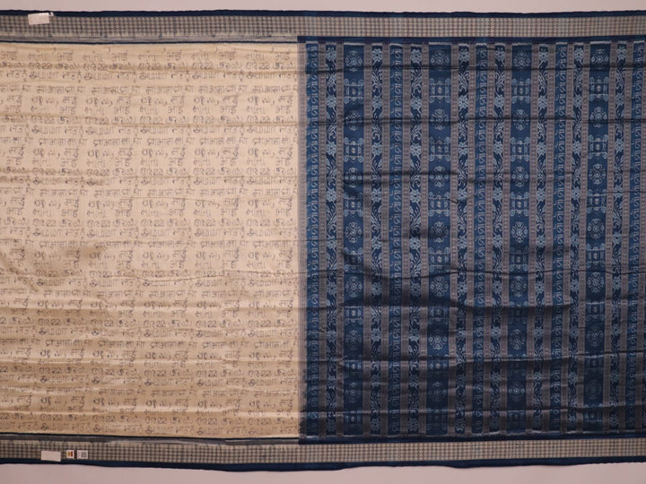 Close-up detail of the cream-colored silk fabric texture with blue motifs in Sambalpuri saree