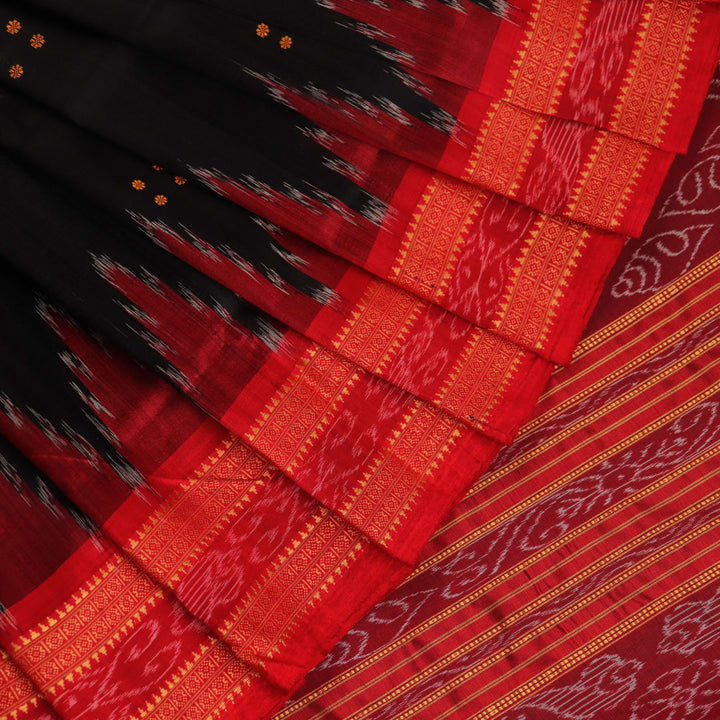 Draping view of a black Khandua silk saree with a red border and butta pattern