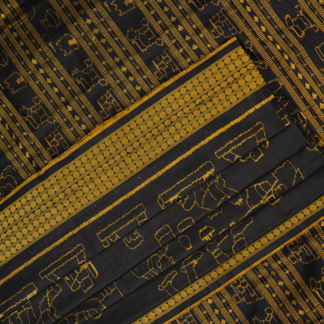 Close-up of the black Sambalpuri silk saree fabric, revealing its rich texture and the intricate weave of the motifs.