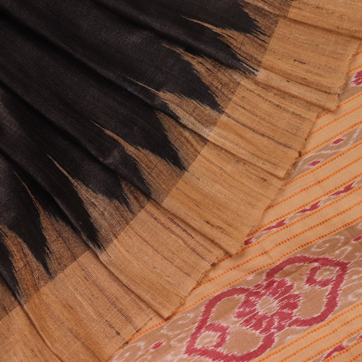 Close-up of black and cream tussar silk sari fabric showing the plain texture.