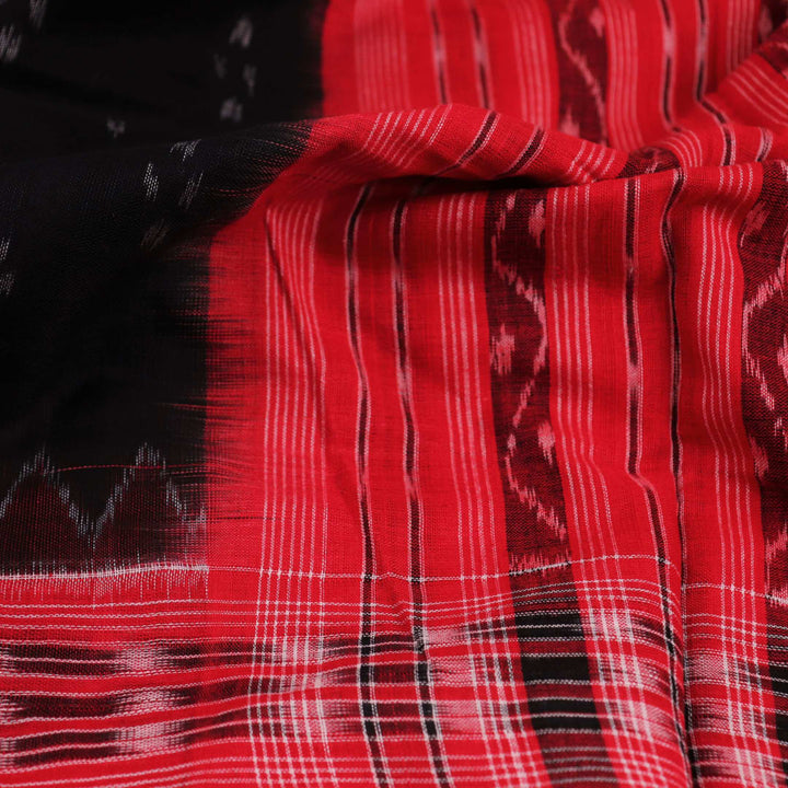 A model drapes a black Sambalpuri cotton dupatta with red motifs and pallu border.