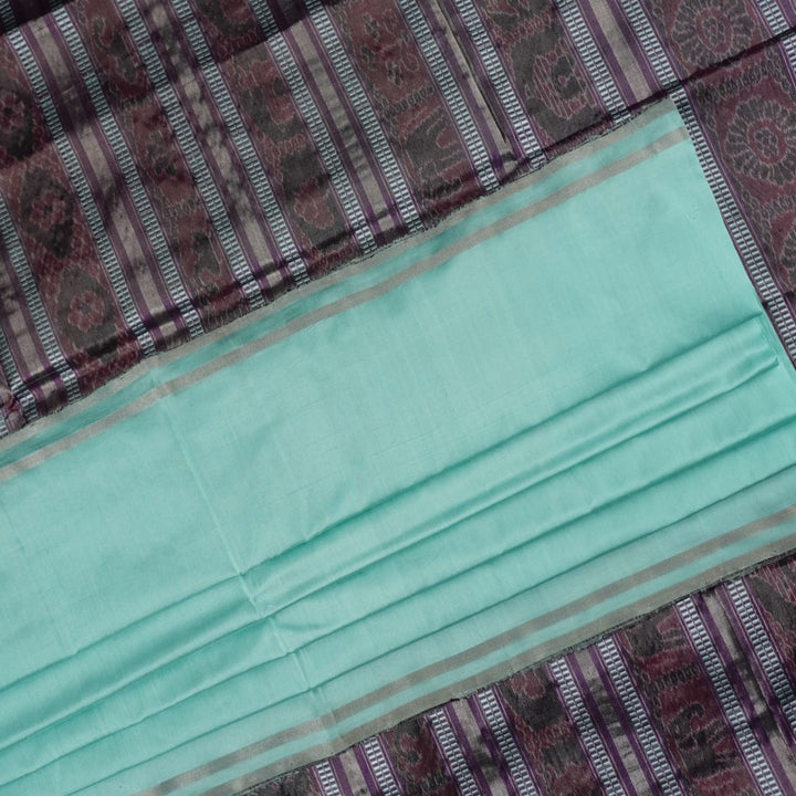 Ultra close-up of the luxurious green Sambalpuri handloom silk weave, highlighting its smooth texture.