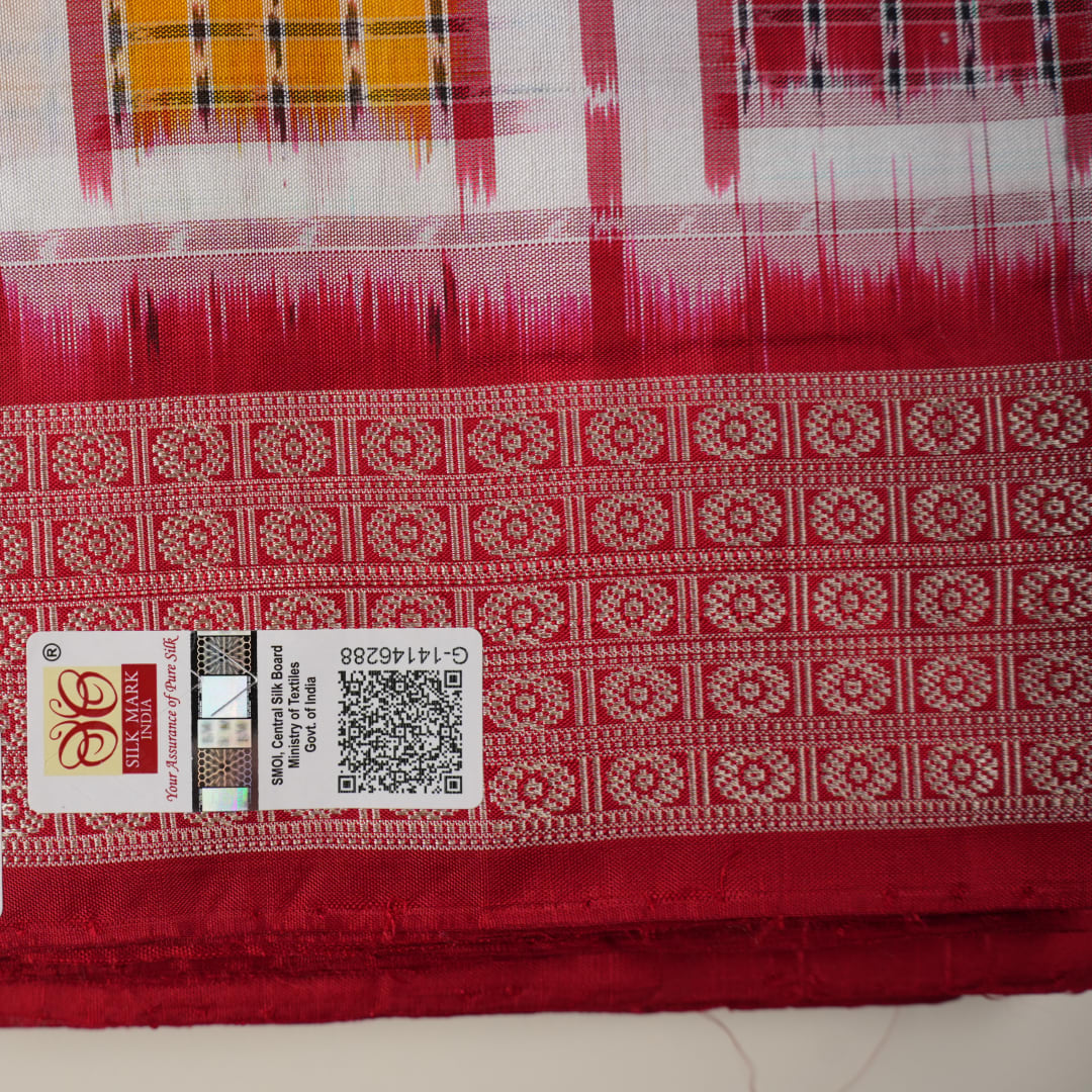 Close-up of the luxurious white Sambalpuri silk saree fabric, highlighting its rich texture and weave.