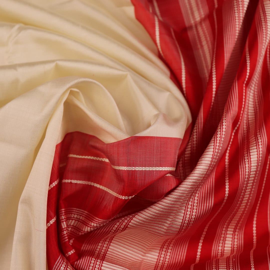 Close-up of plain white silk fabric with intricate Berhampuri weaving in red