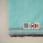 Ultra close-up of the luxurious green Sambalpuri handloom silk weave, highlighting its smooth texture.