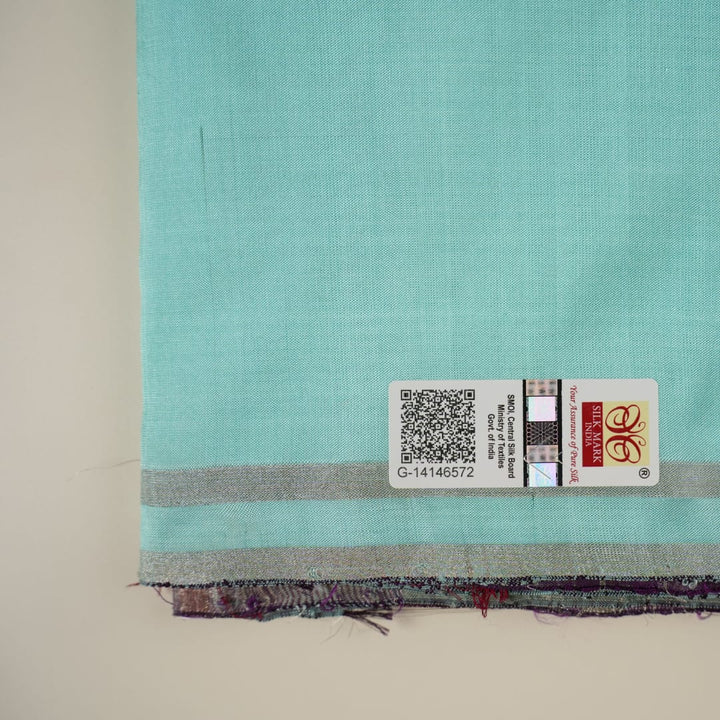 Ultra close-up of the luxurious green Sambalpuri handloom silk weave, highlighting its smooth texture.