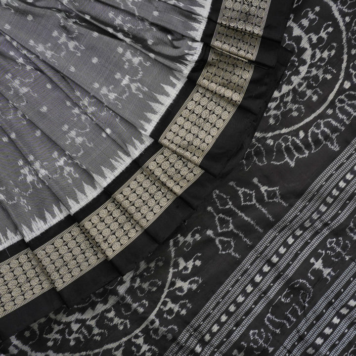 Close-up of grey & black Sambalpuri silk saree fabric, highlighting its rich texture and weave.