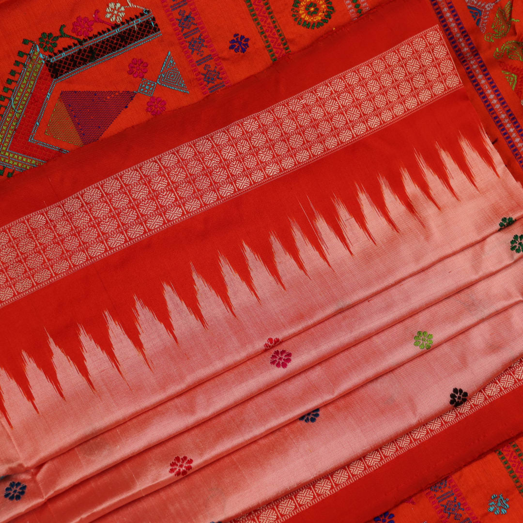 Close-up of finely woven silk fabric featuring intricate Butta patterns in multicolor with an orange accent