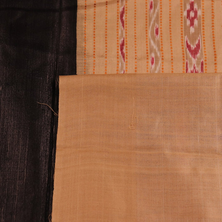 Close-up of black and cream tussar silk sari fabric showing the plain texture.