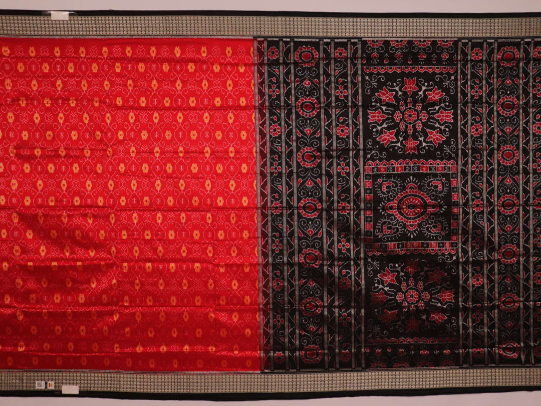 Close-up of red and black silk Sambalpuri saree fabric with intricate motifs