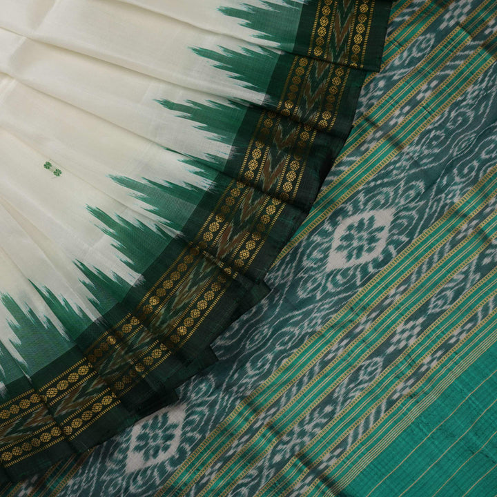 Model wearing a white Khandua silk saree with green butta and border, showcasing a graceful drape.