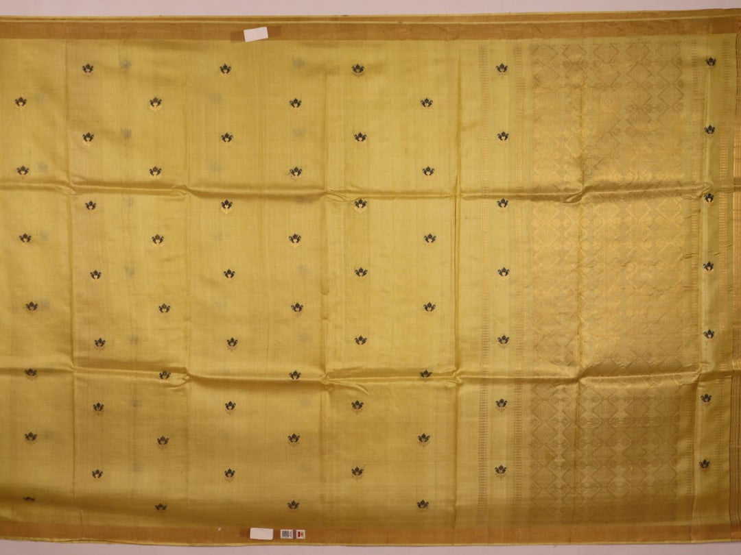 Close-up of yellow Tussar silk saree fabric with intricate butta patterns