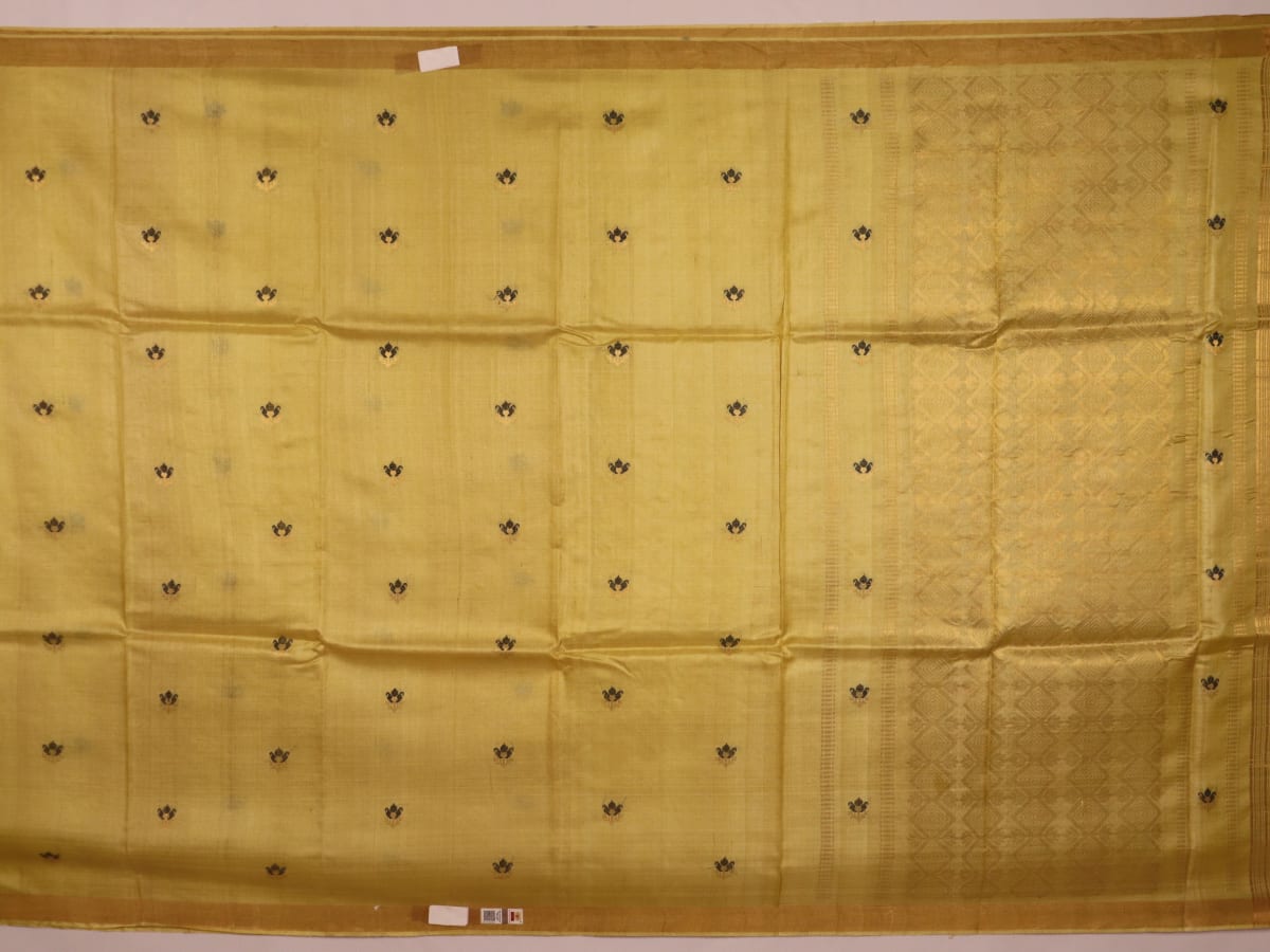 Close-up of yellow Tussar silk saree fabric with intricate butta patterns