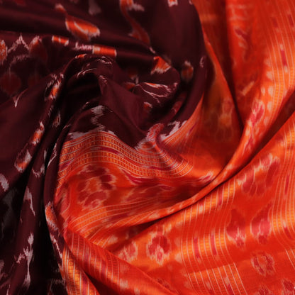 Close-up of maroon and orange Sambalpuri silk saree fabric texture, showcasing handloom weave and motif details.