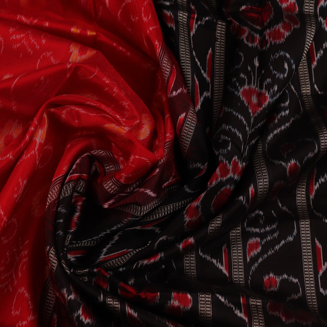 Close-up of red and black silk Sambalpuri saree fabric with intricate motifs