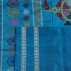 Close-up of the yellow Bomkai silk saree fabric texture, revealing its intricate weave and butta pattern.