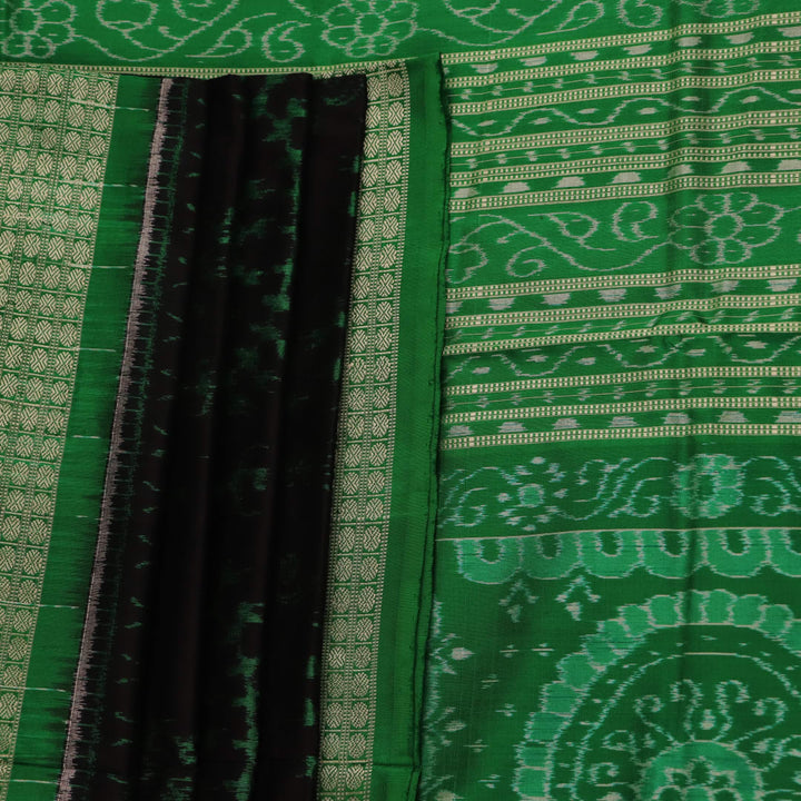 Close-up showcase of the exquisite silk texture with intricate motifs in a black and green Sambalpuri saree.