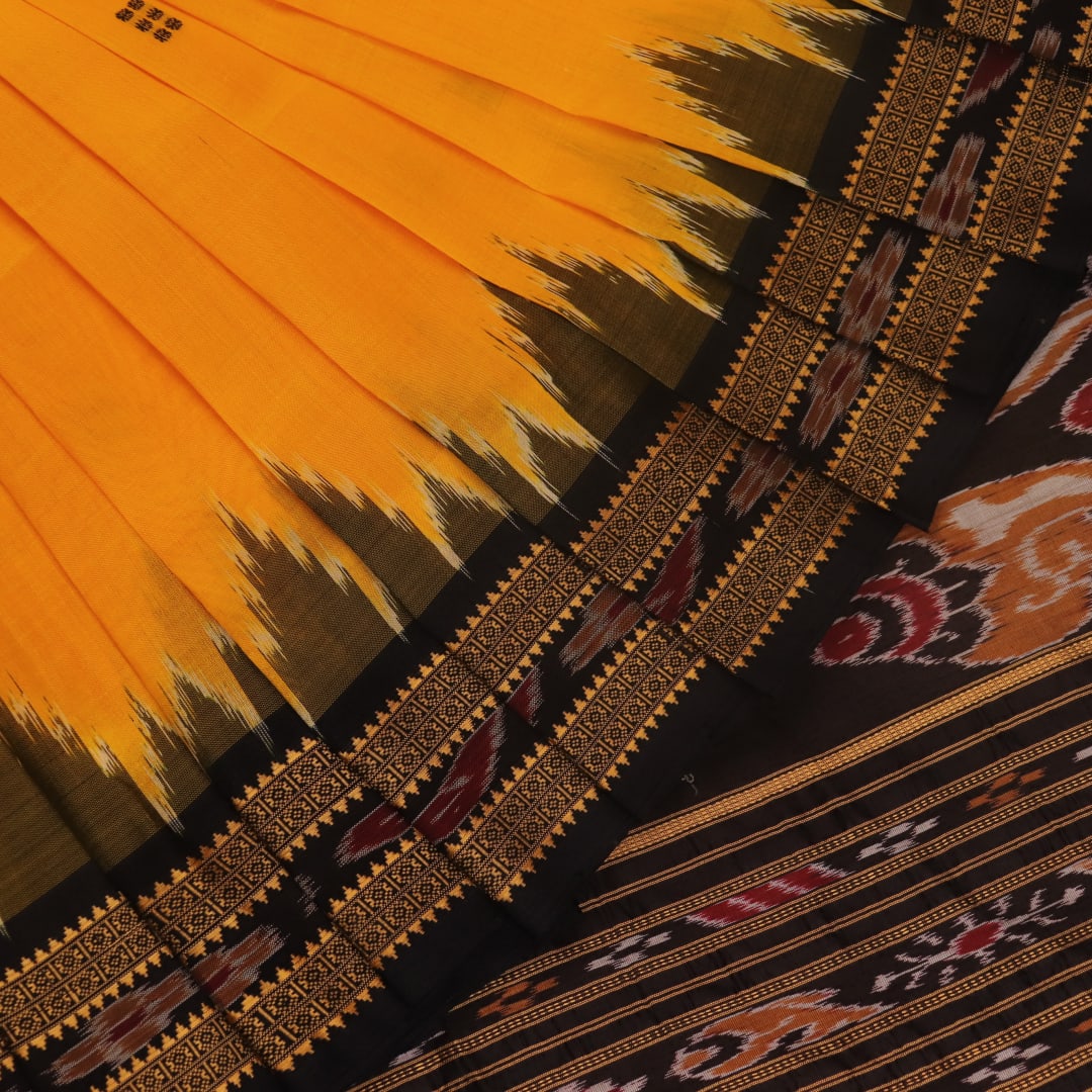 Model showcasing yellow Khandua silk saree with black butta pattern.