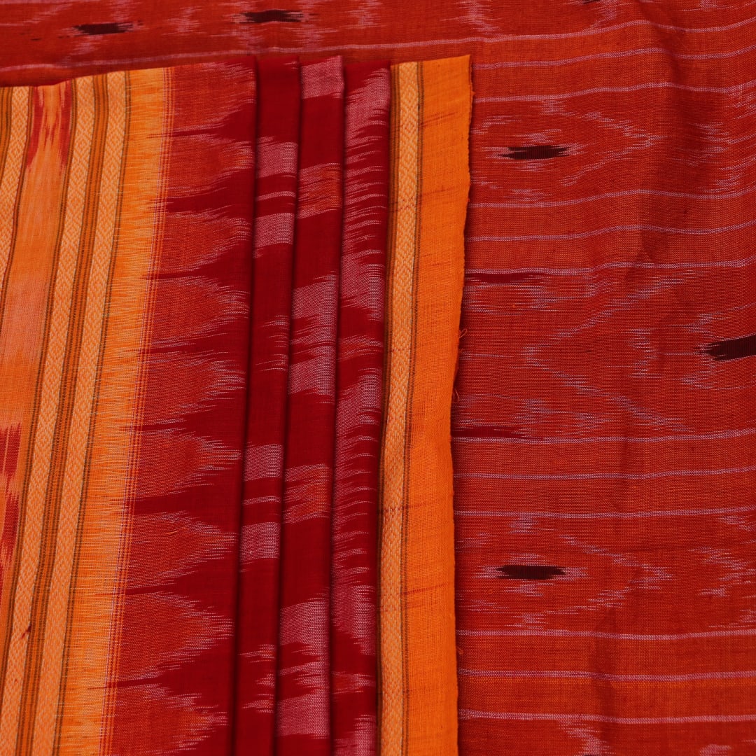 Red and yellow Sambalpuri cotton saree with motifs, elegantly draped to showcase its style.